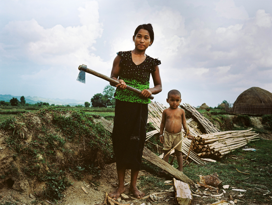 A Rohingya woman and child work in a field within a displaced persons camp in Myanmar. PIC: Ali MC