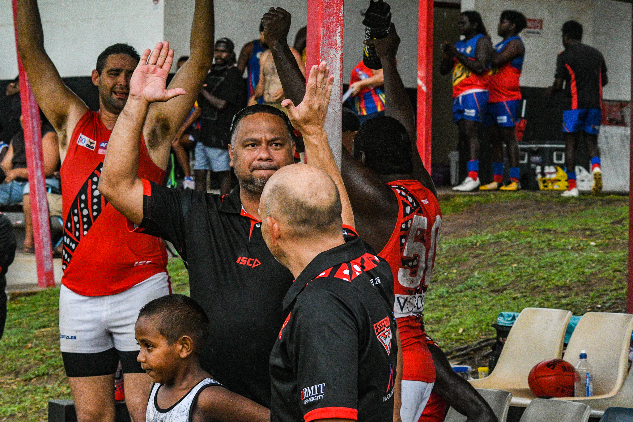 Bombers assistant coach Jeffrey “Yello” Simon high fives Brenton Toy after the final siren against the Crocs. “Yello” is a vocalist and guitarist for popular saltwater Tiwi band B2M. Tiwi Bombers v Southern Crocs, NTFL round 14, January 19, 2019.