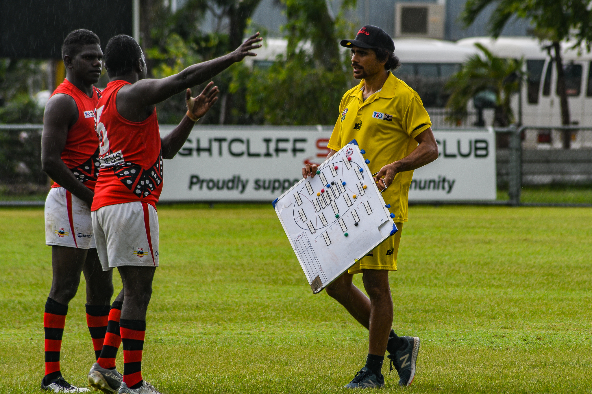 Cyril Rioli Jnr discusses forward line tactics with Tiwi players Simon Munkara and Ross Tungatalum. Tiwi Bombers v Nightcliff Tigers, NTFL round 15, January 27, 2019.