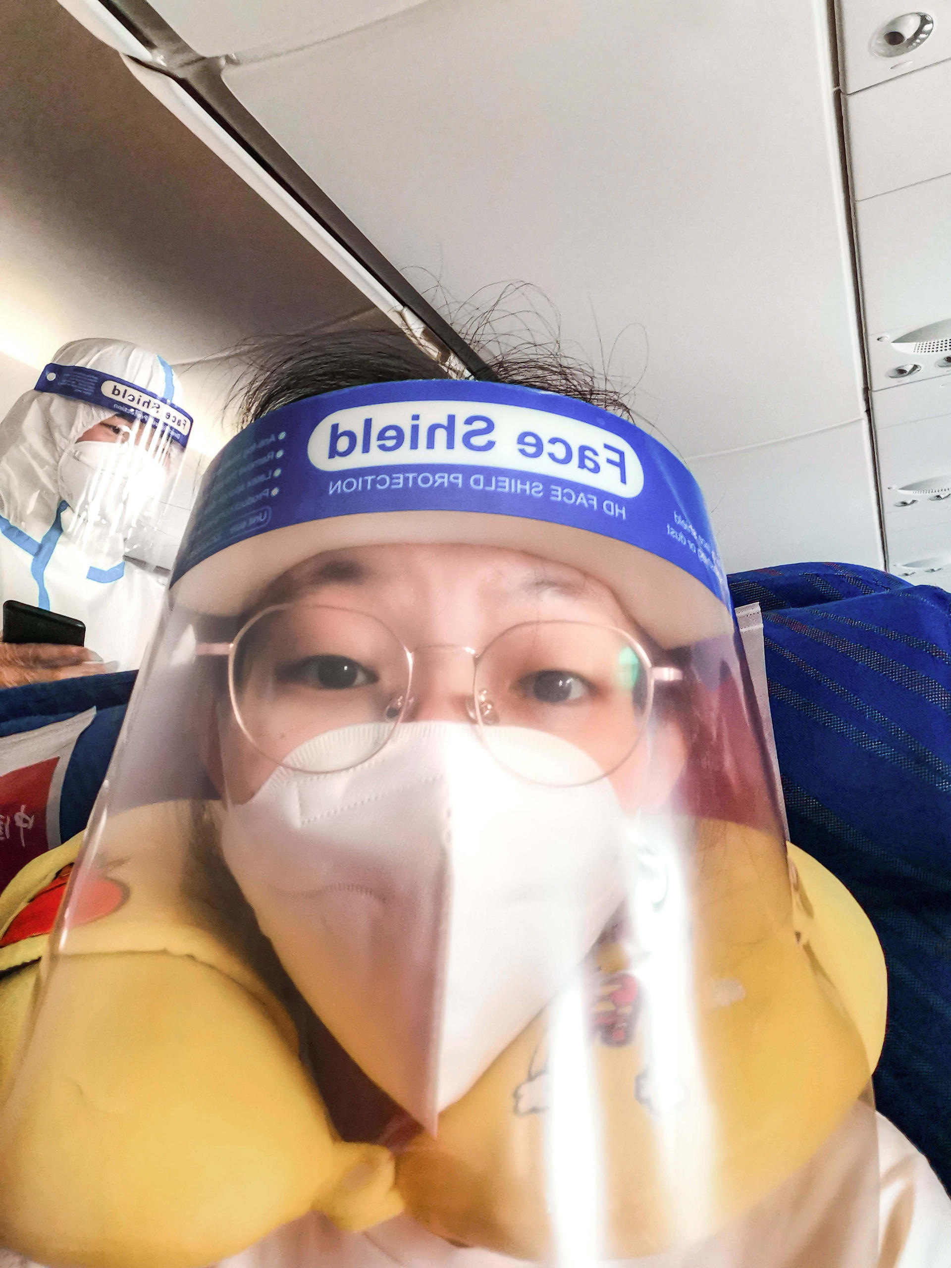 To protect herself from COVID-19, Zifeng wore a N95 mask and a face shield while travelling the long distance on the plane. The flight attendants wore white protection suits. Image credit: Zifeng Zhang