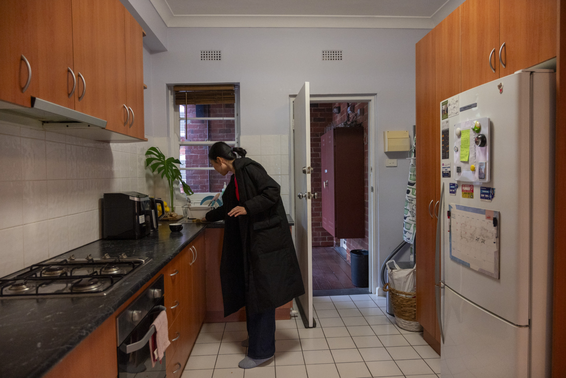 Ling, tidies the kitchen of her rented apartment.