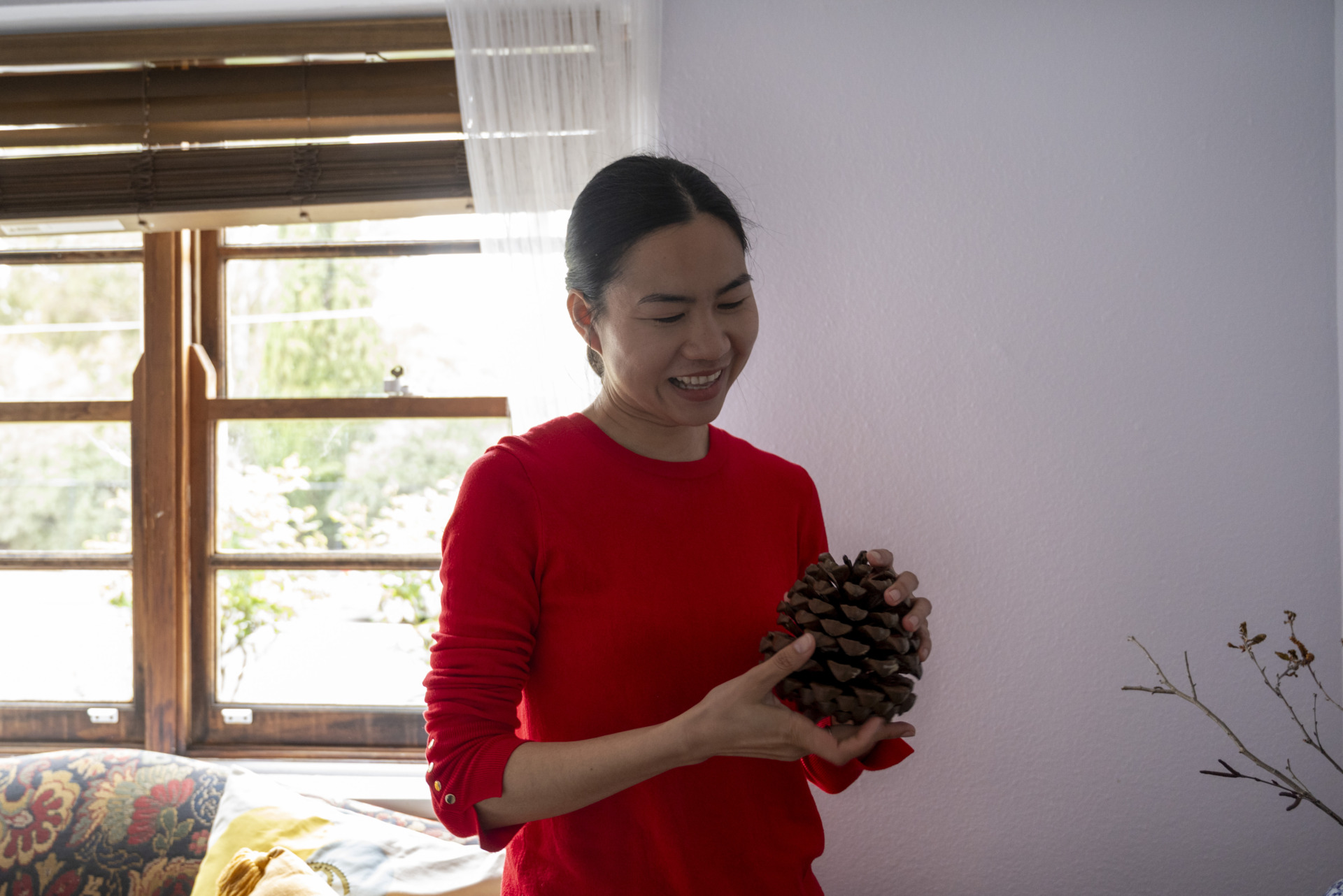 Ling shows off a giant pinecone she found while walking home, after dropping her son at school. She picked it up from a grassy area to decorate her room. Ling sprays the pinecone with a pleasant scent, turning it into a natural air freshener.