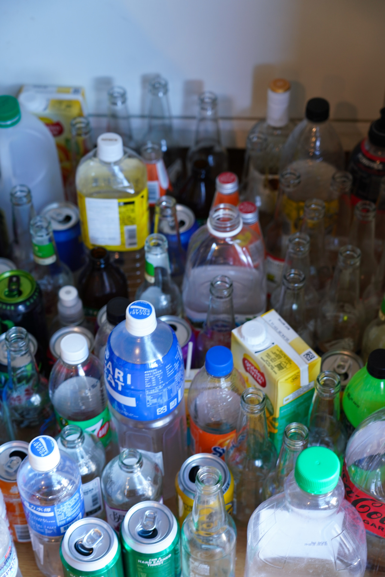 A collection of empty bottles and cans fills a corner of Yang Xihan&rsquo;s shared house in Clayton, Melbourne on October 2, 2024. &ldquo;Each empty bottle is quite clean,&rdquo; Yang explains, showing his recycling system that helps offset his AUD300 weekly rent. The blue Pocari Sweat bottles stand out among soft drink cans and juice containers, waiting to be exchanged for Coles credit points.