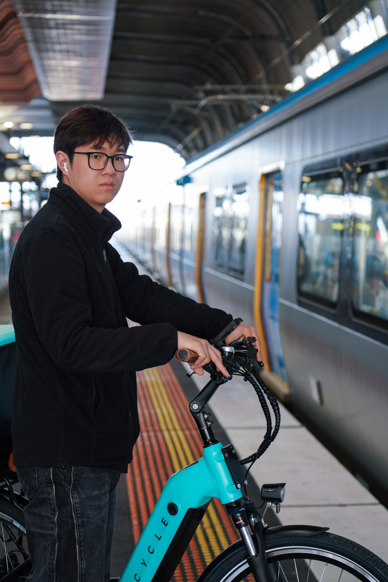 Yang Xihan stands with his e-bike at Clayton Station in Melbourne on October 2, 2024. Having worked various jobs from cafe manager to teaching assistant, Yang now dreams of trying 100 different occupations. &ldquo;I don&rsquo;t want to follow the traditional path,&rdquo; he says. &ldquo;Each job teaches you something unique about business and life.&rdquo; His social media posts about Melbourne&rsquo;s gig economy attract hundreds of followers.