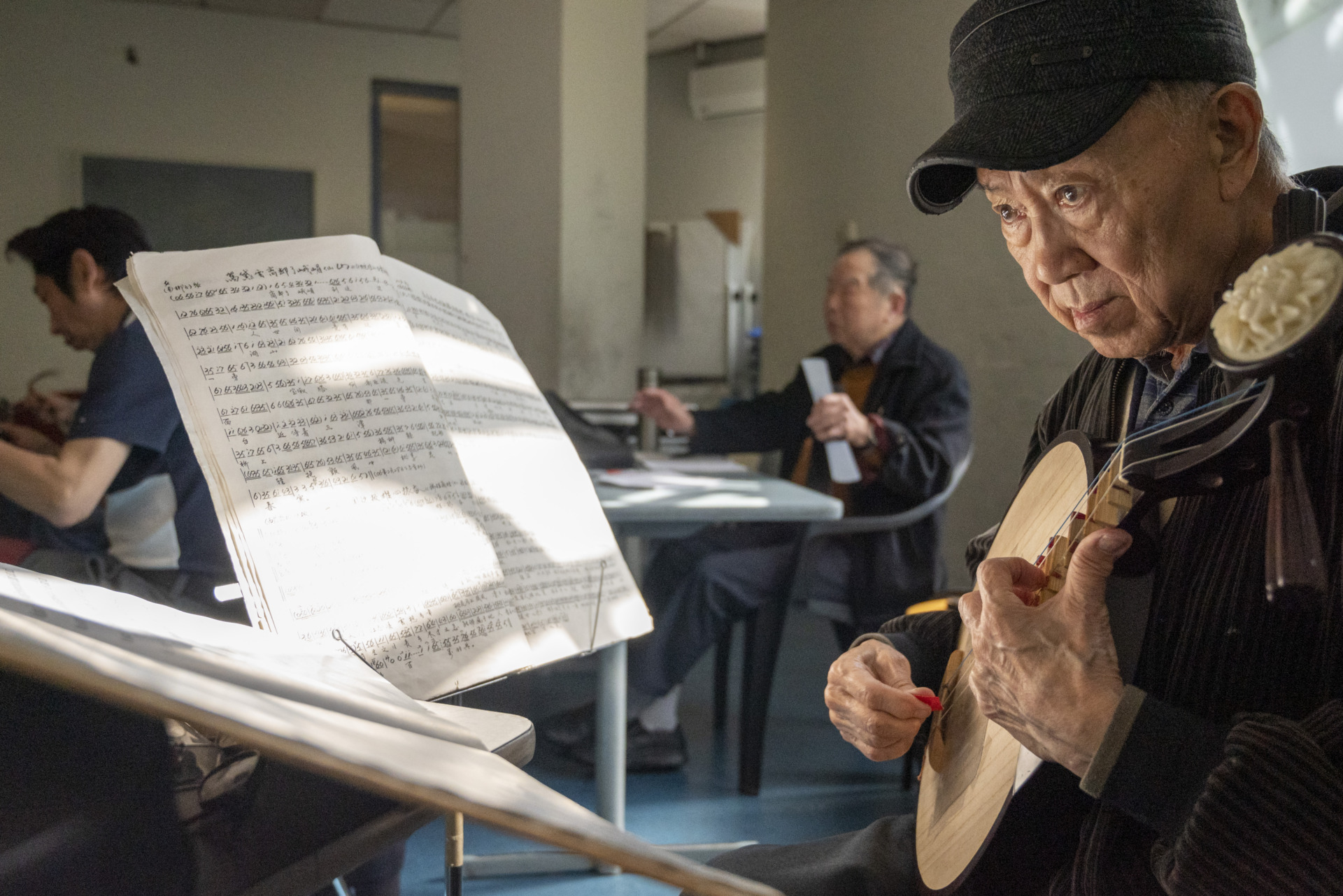 2:00pm This photo was taken during Thursday&rsquo;s rehearsal of Harmony Peking Opera Group, with sunlight streaming through the window onto the music sheet. At the North Melbourne rehearsal venue, member Jiedong Huang intently plays the Yueqin, his eyes focused and fingers skilfully strumming the strings.