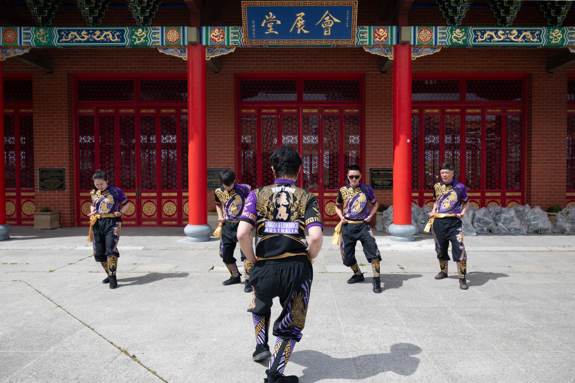 5 October 2024.&nbsp; Before formal lion dance rehearsals at the Heavenly Queen Temple in Footscray, Melbourne, Australia, Benjamin Lam leads the team in a brief outdoor warm-up and physical training session to prevent injuries during the intense practice. He faces the members, controlling the rhythm by shouting slogans and ensuring that each member&rsquo;s movements are standard.