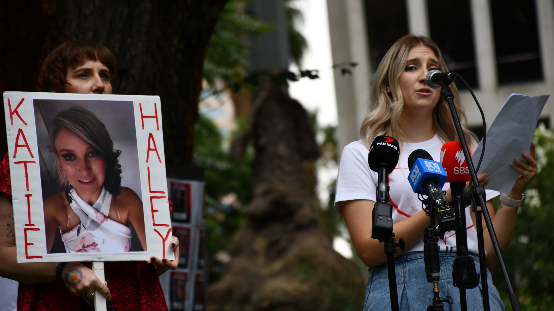Bianca Unwin (pictured right), a vocal advocate against gendered violence since the 2018 murder of her sister Katie Haley, stands alongside artist Dans Bain (pictured left), who holds a portrait of Katie. Photo: Ashleigh Wyss