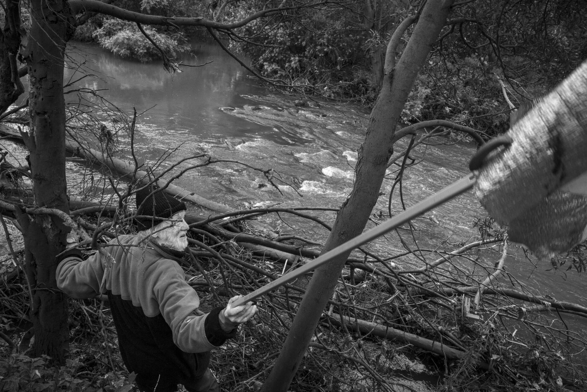 Friends of Merri Creek volunteer, Paul Prentice pulling a car sun shade out of the creek near Clara Street, Brunswick East. &ldquo;That&rsquo;s a satisfying one,&rdquo; Prentice said. Prentice, 83 has been cleaning the creek for over 30 years. Most creek maintenance is done by community volunteers. Photo by Ruby Perryman