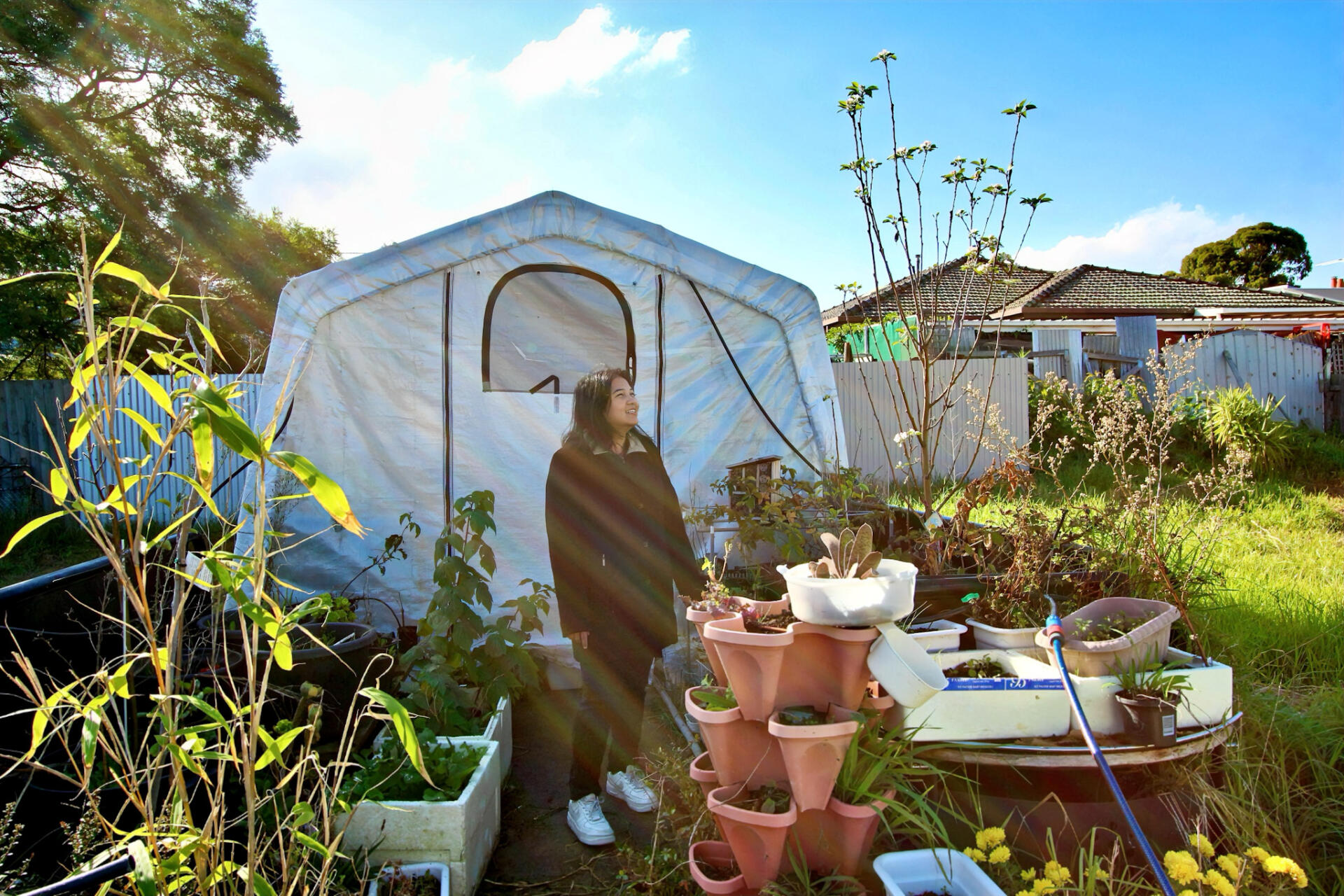 Zin Nguyen, a volunteer at The Op Shop, takes a peaceful walk in the backyard, soaking up the afternoon sun.