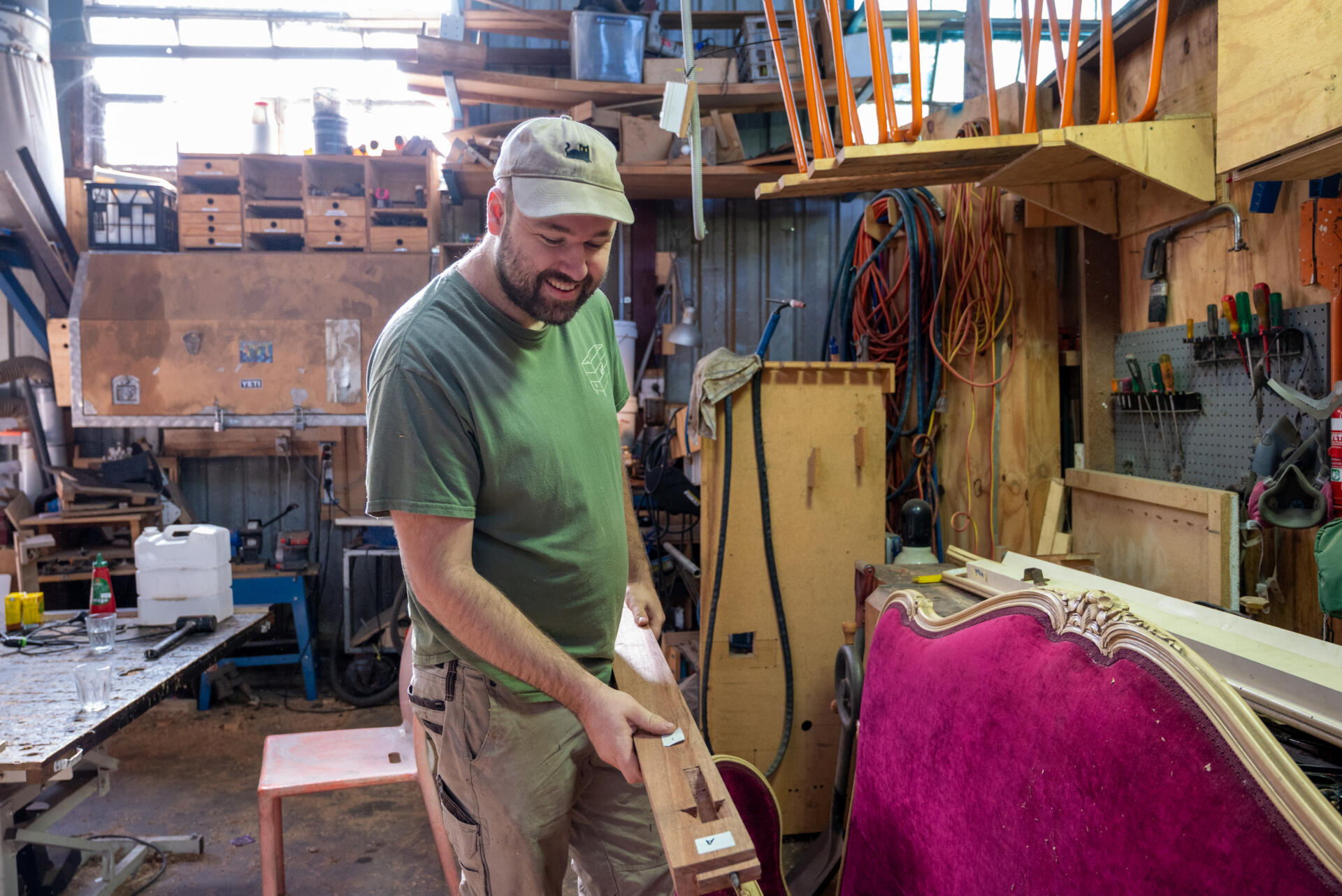 Tom Scott, a furniture maker and FML board member, works on a handmade wooden frame in his studio. He collaborates with his father, who designs digitally while Tom brings those ideas to life by hand.