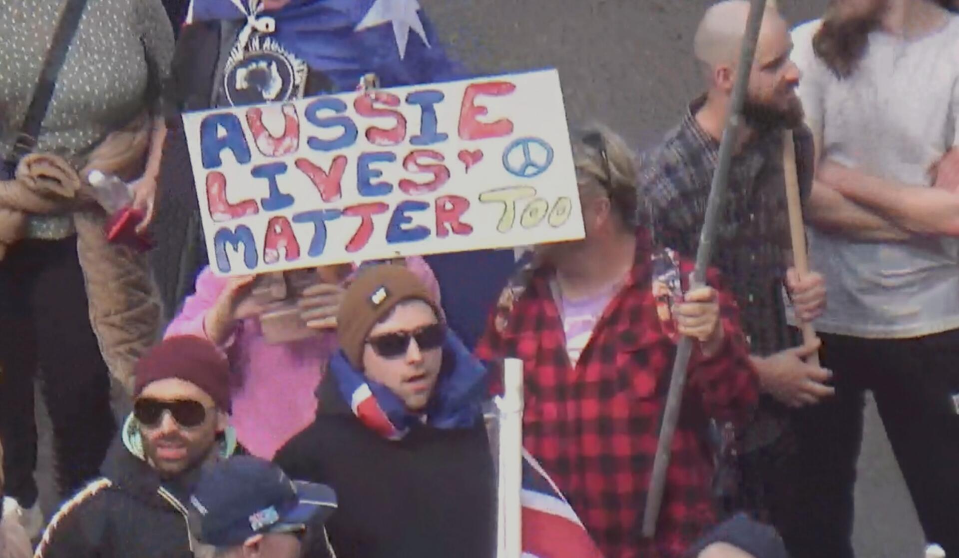 Rally attendee brandishing &ldquo;Aussie lives matter too&rdquo; sign. Photo by Alexandra Nevill.
