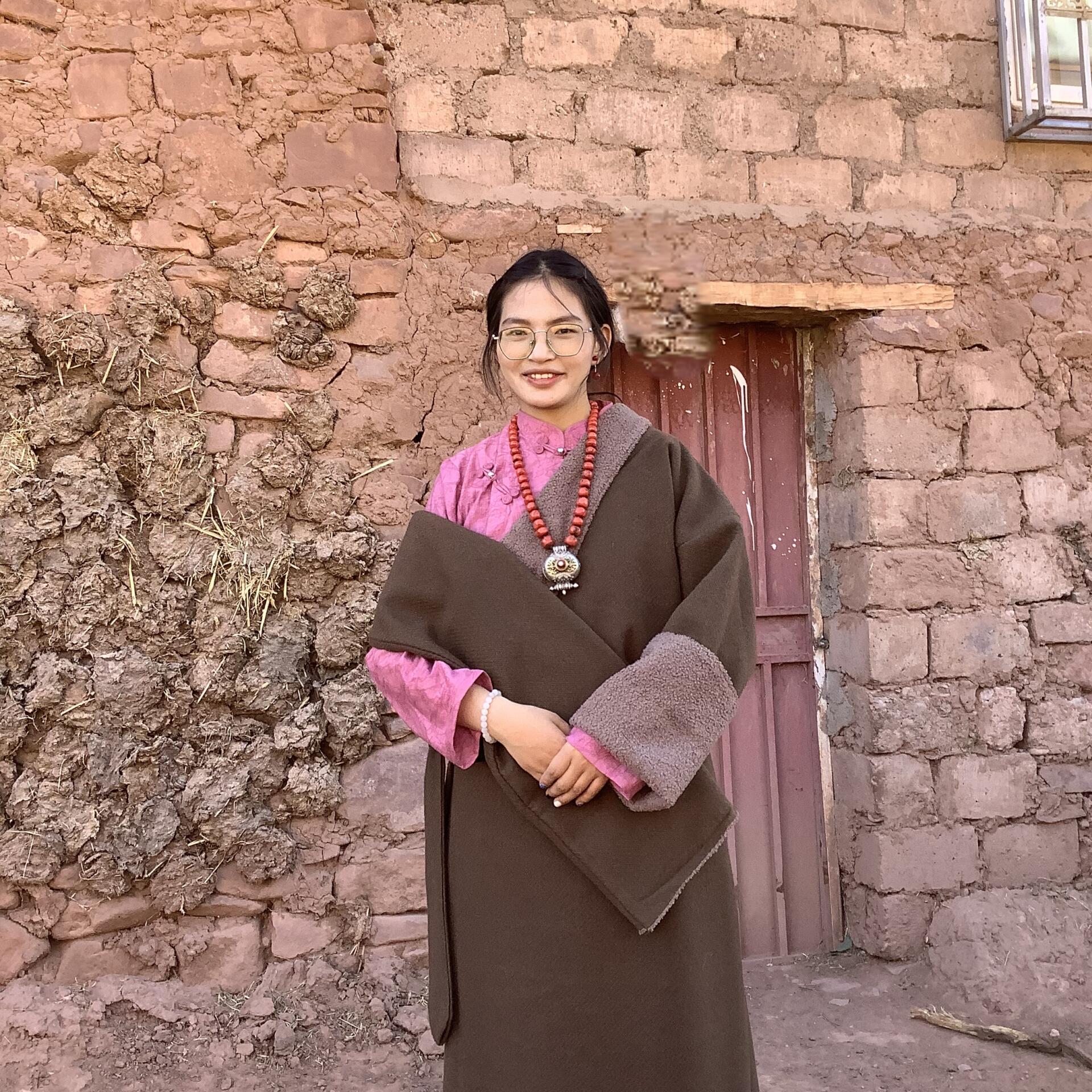 Luobuzhuoma standing in front of her home. Photo supplied by Luobuzhuoma.