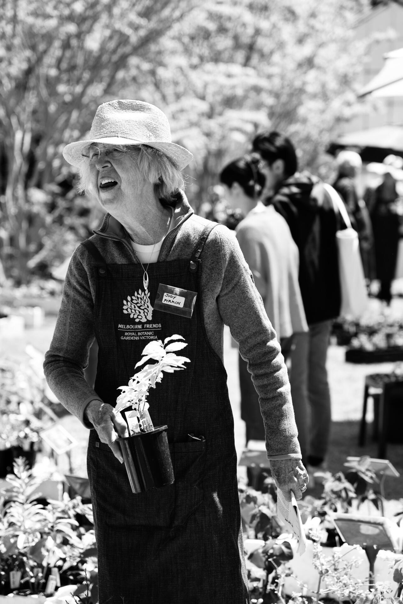 A &ldquo;Growing Friends&rdquo; volunteer holds a plant for sale at the Spring Plant Sale