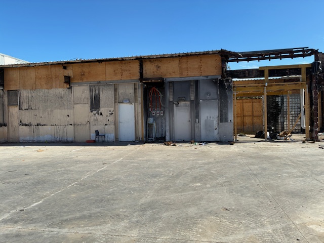 The empty lot that the Synagogue used to be on. The black melted and charred walls are still visible. Everything in the image will soon be torn down. Photo by Lewis Weir.