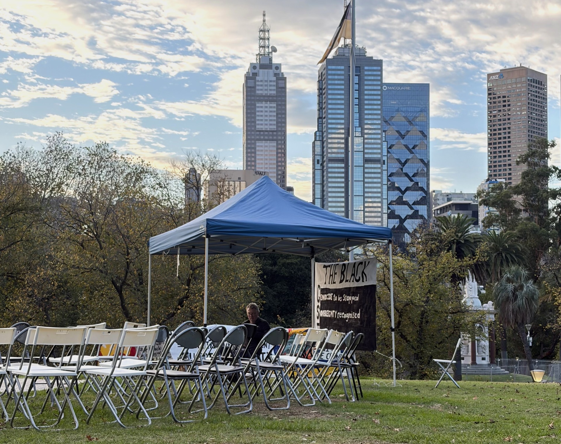 A lone gazebo with a &ldquo;Black GST&rdquo; sign sits before the Melbourne skyline. Photo: Matt Melia.