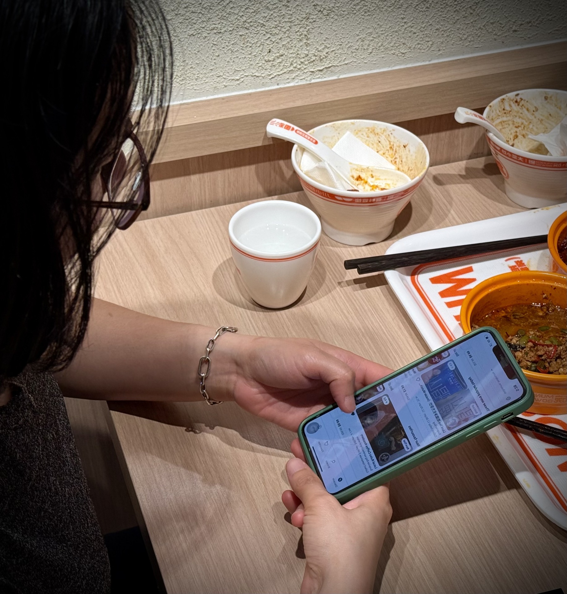 Nguyen scrolling the &lsquo;Too Good To Go&rsquo; app after finishing dinner at an affordable Chinese restaurant in Elizabeth Street. Photo: Joyce Le.