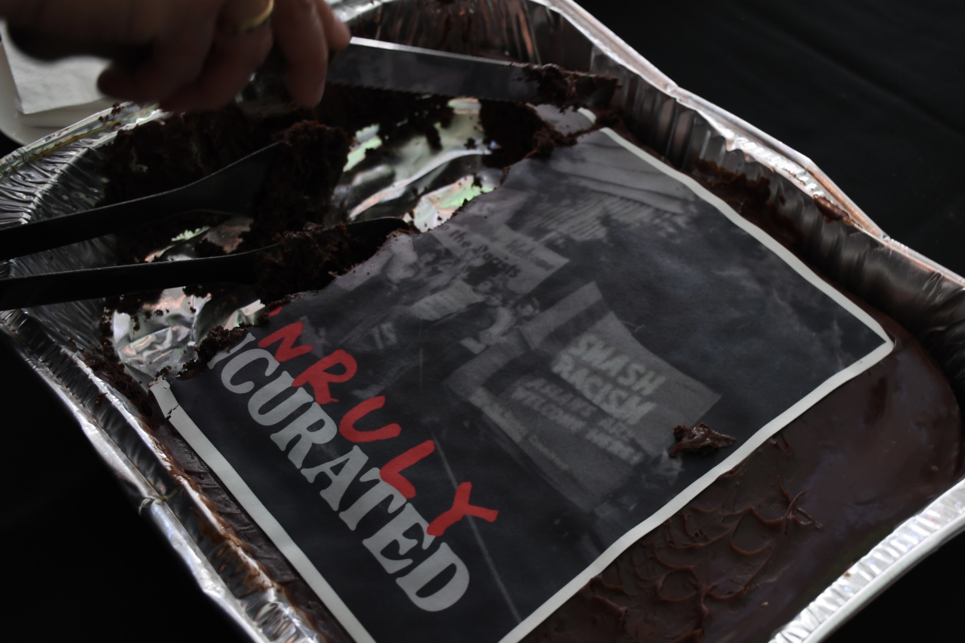 A cake at the launch is topped with the season&rsquo;s cover art, an archival photograph of protesters holding placard, including one that says &ldquo;Smash racism&rdquo;. Photo by Preeshita Shah.